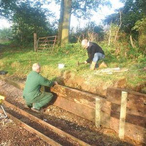 The first task was to set up a laser level to maintain the gradient profile between the two untouched sections of line. The first section to be lifted is in front of the laser. At the same time, the new sleep wall is being constructed behind.